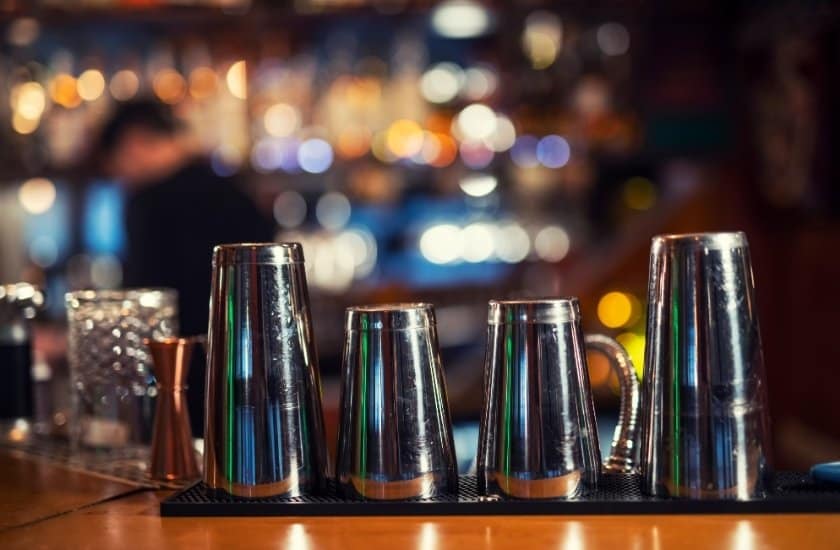 tin on tin cocktail shakers on bar counter