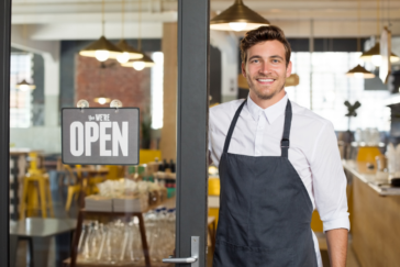 man with open sign at doorway