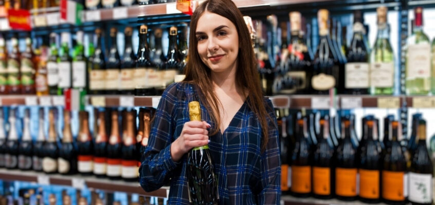 woman with champagne bottle in liquor store