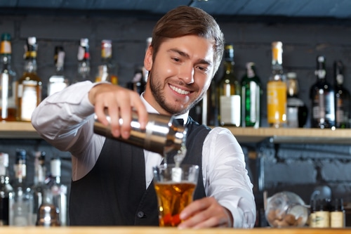 Handsome California alcohol server with bartender license during work day pouring drink