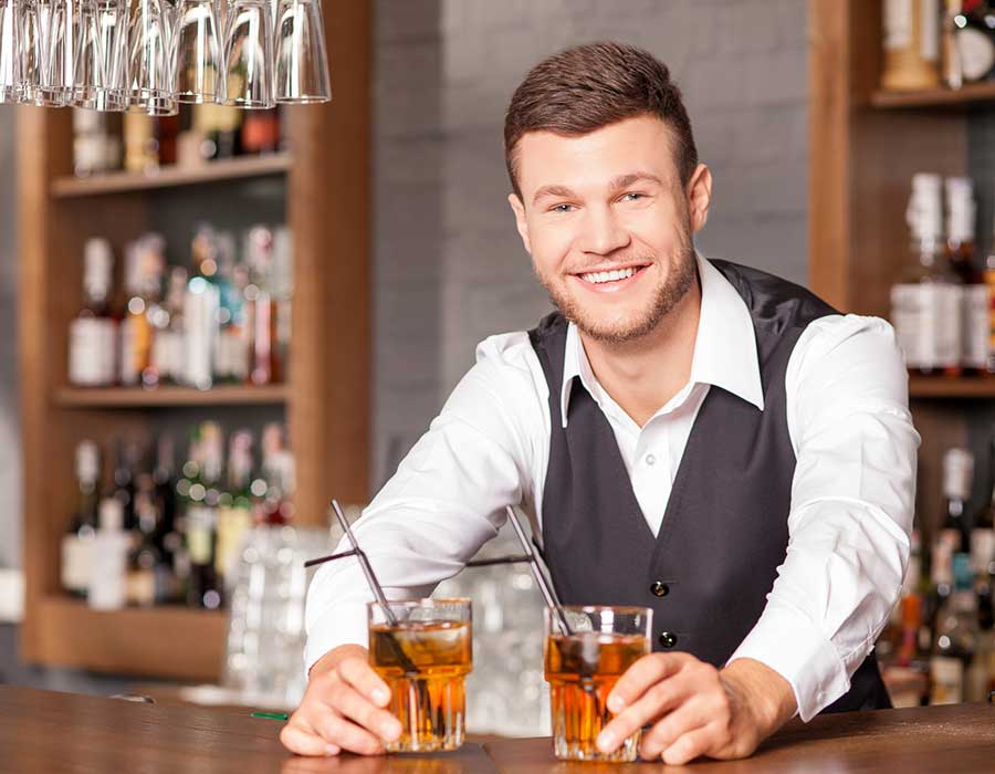 bartender serves a couple of drinks from behind the counter